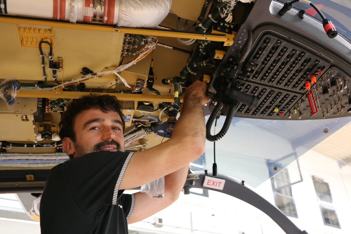Helikoptermechaniker Timo Inauen am Arbeiten im bis aufs Skelett freigelegten Kabinendach.